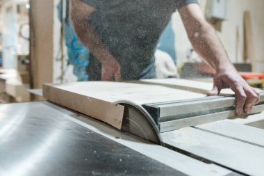 Kafkasyalı marangoz dairesel testereyle odun kesiyor ve yeni mobilyalar yapıyor.