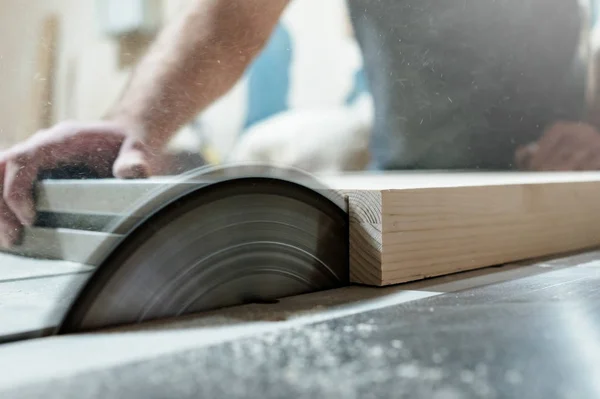 Caucasian man carpenter cutting wood with circular saw creating new furniture — Stock Photo, Image