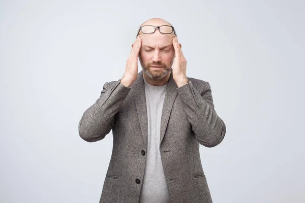 Man met bril en gesloten ogen aanraking tempels lijdt aan bonzende hoofdpijn — Stockfoto