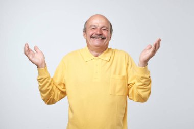 Man smiling on grey background laughing. Positive facial emotion