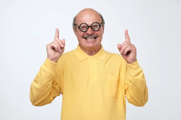 Crazy senior man in funny glassespointing index finger up — Stock Photo, Image