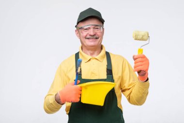 Painter man at work with a paint roller, standing with confident expression