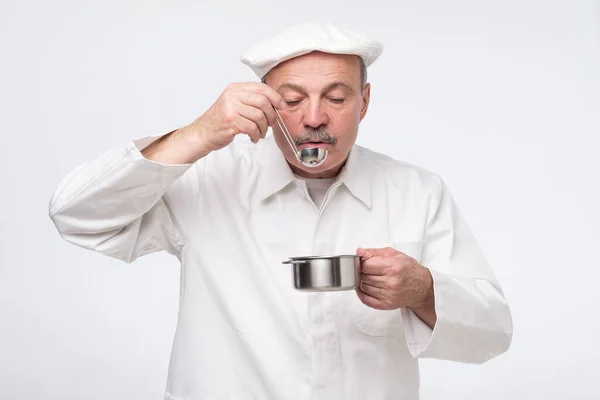 Sénior hispânico chef masculino cozinhar e cheirar a comida na cozinha — Fotografia de Stock