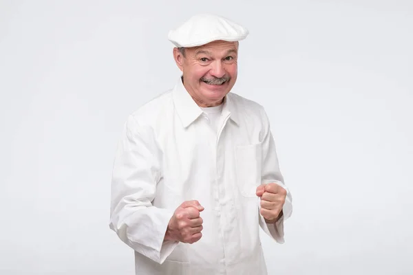 Excited chef guy in uniform is happy with success saying yes holding fists. — Zdjęcie stockowe