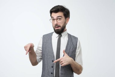 Modern young hispanic businessman pointing down on copyspace.