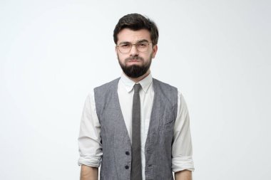 Kızgın sinirli genç adam, kameraya bakıyor ve öfkeden yanaklarını şişiriyor. Stüdyo çekimi