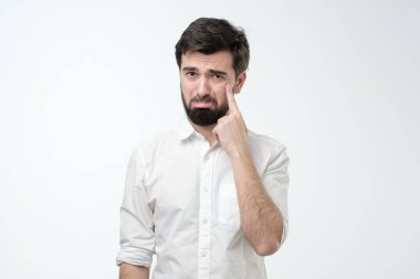 Üzgün genç İspanyol adam ağlamak üzere. Negatif yüz insani duygu. Stüdyo çekimi