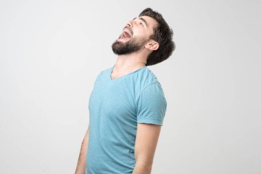 Havalı kıyafetler içindeki yakışıklı İspanyol adam yukarı bakıp gülüyor. Olumlu yüz insani duygu.