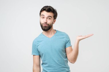 Genç İspanyol adam, el bilgisayarında, beyaz arka planda izole edilmiş metnin için kopyalama alanı olan bir şey gösteriyor..