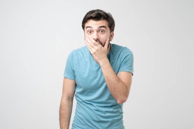 Ağzını eliyle kapatan yakışıklı İspanyol. O, şaşkınlıktan sesini kaybetti. Stüdyo çekimi