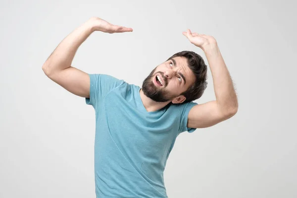 Young Hispanic Man Pretending Hold Heavy Sign Studio Shot — Stock Photo, Image