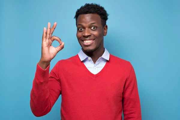 Африканський американець має щасливий погляд, посміхається, жестикулює, показує ОК знак — стокове фото