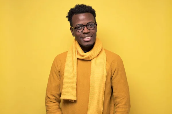 Giovane bell'uomo d'affari africano in maglione giallo e sciarpa sorridente — Foto Stock