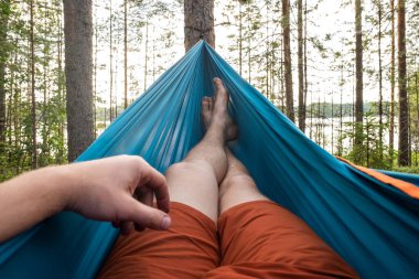 Ayaklar hamakta Çam ormanının arka planında