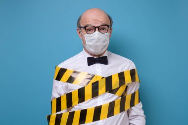 Mavi izole edilmiş virüslerden ve enfeksiyonlardan korunmak için koruyucu tıbbi maskeli kıdemli adam. Coronavirus 2019-ncov covid-19 konsepti. Karantinada kalın.