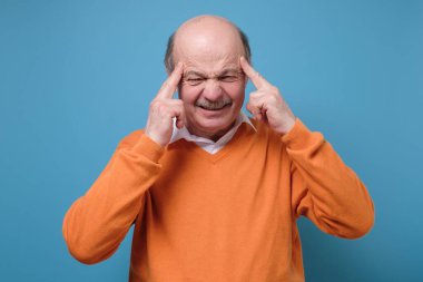 Avrupalı adam parmaklarını şakakların üzerinde tutuyor, gözleri şaşı bakıyor, bir şeyler hatırlamaya çalışıyor. Baş ağrısı çekiyor, parmaklarıyla şakağına masaj yapıyor.