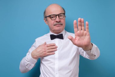 Kafkasyalı kıdemli işadamı avuçlarını kaldırıyor ve iğrenç bir ifadeyle reddediyor. Salgın sırasında mesafeyi koru.