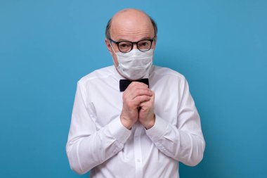 Coronavirus 'un hastalığından korkan tıbbi maskeli yaşlı bir adamın portresi. Stüdyo çekimi.