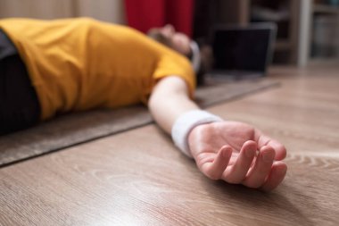 Genç bir adam yerde meditasyon yapıyor ve Shavasana 'da oturma odasında poz veriyor. Evde kal ve yoga yap. Rahatla, meditasyon konsepti.,