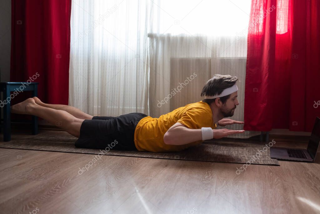 Sporty Muscular Young Yogi Man Doing Backbend Salabhasana Locust Pose Double Leg Kicks At The Living Room At Home 361510624 Larastock