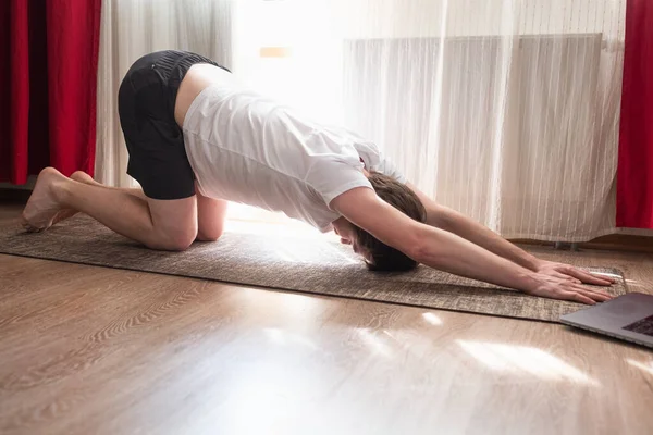 Stretching spine asana. Young caucasian man practicing yoga at home — Stock Photo, Image