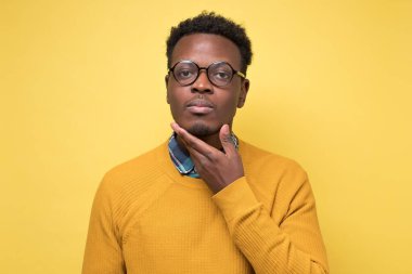 Sarı elbiseli, düşünceli, yakışıklı Afro-Amerikan.