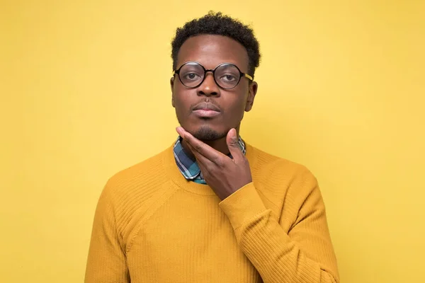 Нахабний задумливий афроамериканець у жовтому одязі, який дивиться і думає — стокове фото
