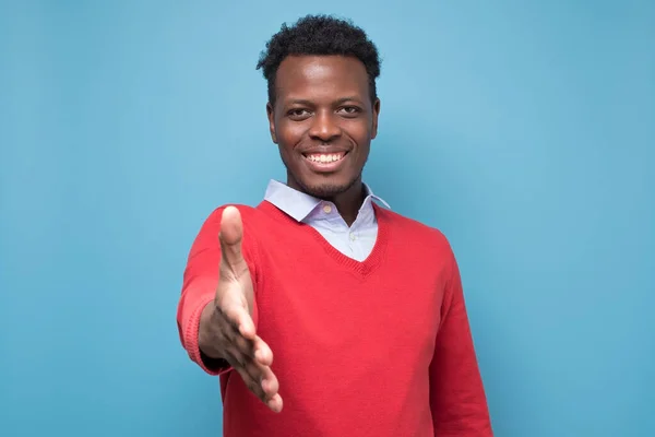 Joven hombre afroamericano extendiéndose hacia la cámara para estrechar manos — Foto de Stock