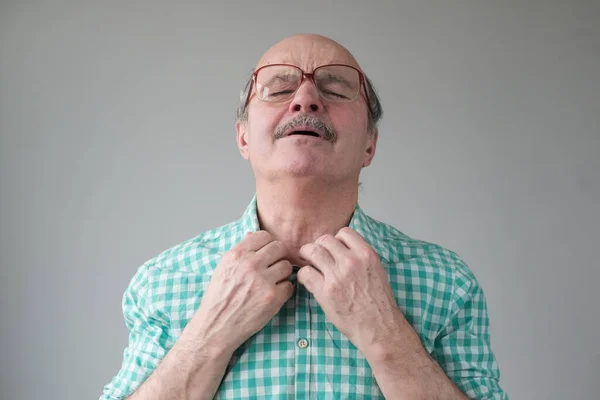 Hombre hispano mayor que sufre de calor. Estudio de tiro en la pared gris . —  Fotos de Stock