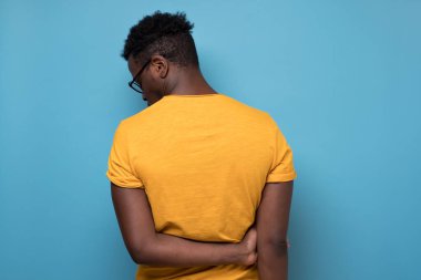 Bir Afro-Amerikan portresinin arkasını dönmesi hüzünlü bir umutsuzluk ya da mavi arka planda yalnız bir stüdyo.