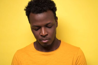 Genç afro-amerikan adam suçlu bir ifadeyle aşağıya bakıyor, nerede çalıştığı hakkında hiçbir fikri yok. İnsan yüzü ifadeleri, duyguları ve duyguları