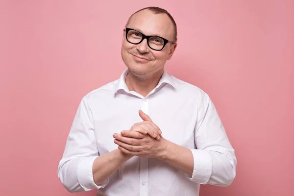 Χαμογελαστός ώριμος άντρας με γυαλιά και λευκό πουκάμισο στέκεται κοιτάζοντας την κάμερα — Φωτογραφία Αρχείου