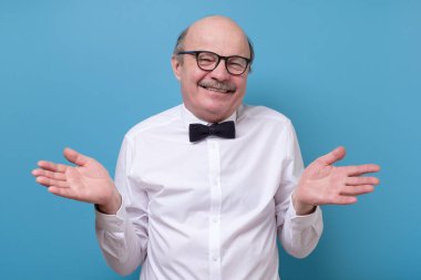 Kafası karışmış, gözlüklü beyaz adam stüdyoda el kaldırmaktan emin değil.