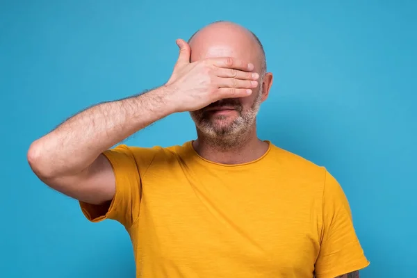 Blanke volwassen man bedekt zijn gezicht met de hand gevoel gestrest en alleen — Stockfoto