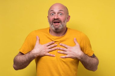 Şaşırmış yetişkin bir adamın el ele tutuşması, ağzını açık tutması.