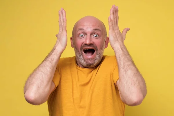 Verbazingwekkende volwassen man houdt handen in verrast gebaar, houden mond wijd open — Stockfoto