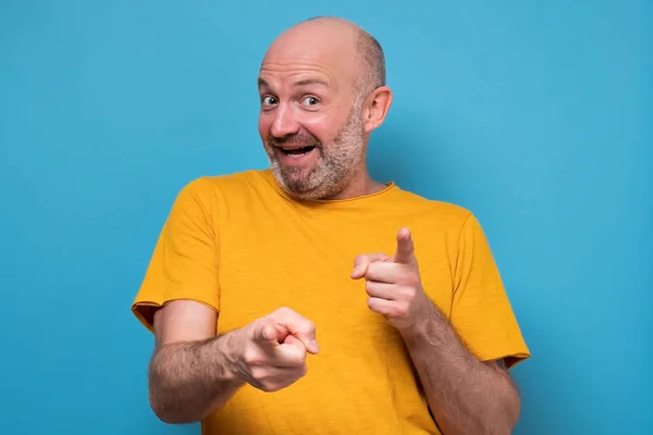 Ώριμος χαρούμενος άντρας με κίτρινο casual πουκάμισο που κοιτάει την κάμερα και γελάει — Φωτογραφία Αρχείου