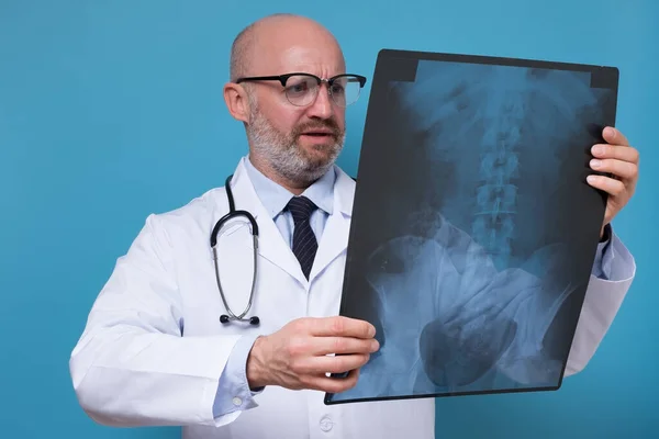 Зрілий лікар в окулярах і біла уніформа спостереження рентгенографії хребта — стокове фото