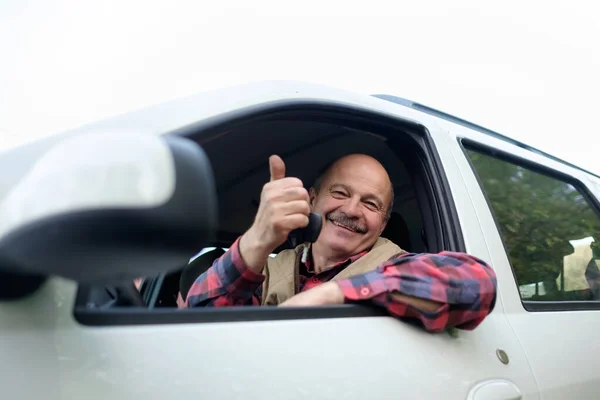 Hombre hispano mayor conduciendo un coche y mostrando los pulgares hacia arriba — Foto de Stock