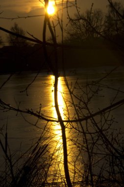 Donmuş bir gölün üzerinde akşam güneşinin güzelliği