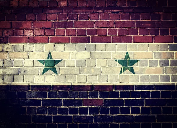Grunge Syrië vlag op een bakstenen muur — Stockfoto