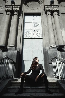 Bisikletçinin ceket pozlar vintage daireli ev bahçesinde giyen Doğu güzel kadın