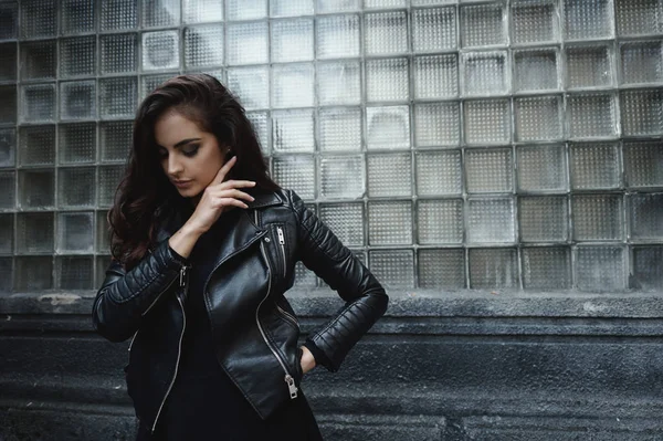 Orientale bella donna indossa motociclista giacca posa in cortile di vintage condominio — Foto Stock
