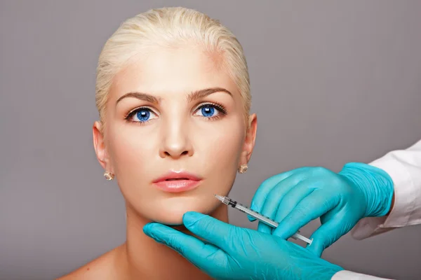Cosmetic plastic surgeon injecting aesthetics face Stockbild