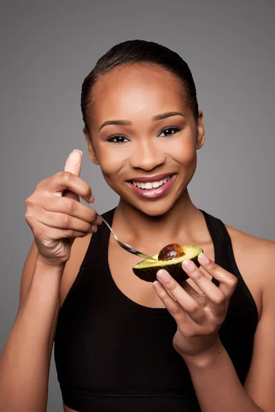 Feliz saudável preto asiático mulher comer abacate — Fotografia de Stock