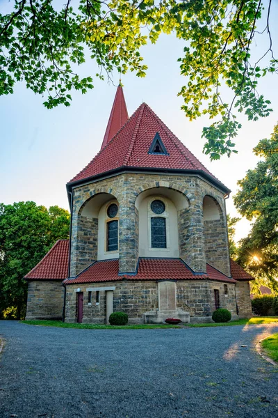 Antigua iglesia rústica al atardecer en un pequeño pueblo — Foto de Stock