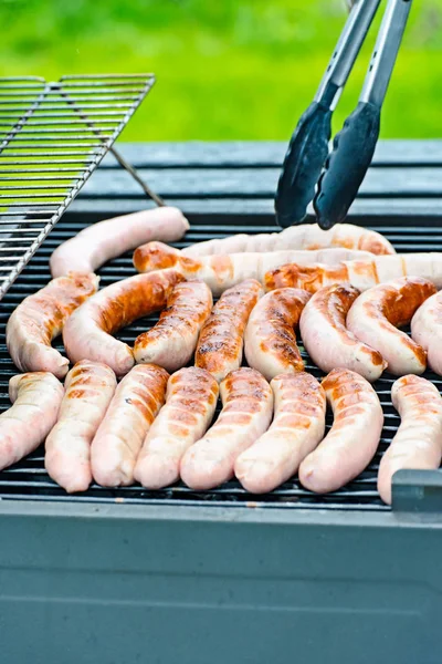 Les saucisses sont sur le barbecue au charbon de bois. — Photo