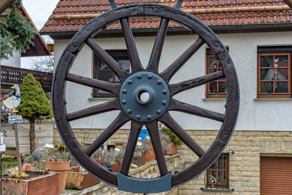 Roda de uma carruagem está pendurada no portão para decoração — Fotografia de Stock