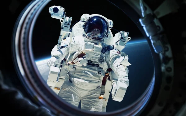 Planète terrestre et astronaute dans un hublot de fenêtre de vaisseau spatial. Éléments de cette image fournis par la NASA — Photo