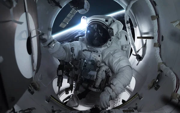 Astronauta en la estación espacial internacional orbitando el plan de la Tierra — Foto de Stock